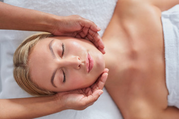 Fototapeta na wymiar Attractive woman getting head massage at dayspa