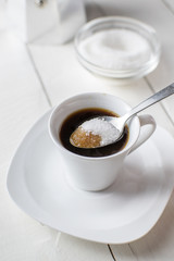  Pouring sugar on coffee cup.
