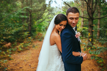 newlyweds in park.newlyweds on walk in the beautiful wood.newlyweds embrace.embraces of newlyweds.newlyweds in the spring wood.gentle.relations.feelings.beautiful groom and bride.fantastic wedding.