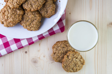Milk glass and plate with oatmeal cookies