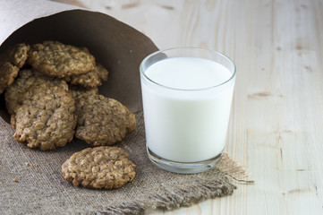 Oatmeal cookies and glass of milk on burlap napkin