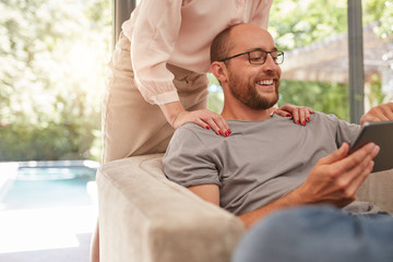 Smiling man using digital tablet at home