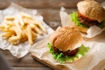 Homemade tasty burger and french fries on wooden table