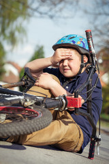 Naklejka premium Boy fell from the bike in a park