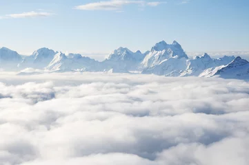 Fotobehang Sharp mountain peaks sticking out of clouds © k1777