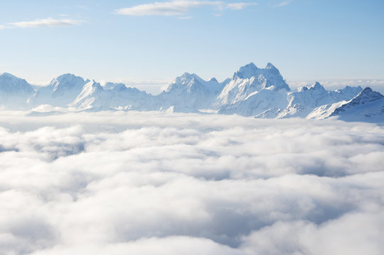 Sharp mountain peaks sticking out of clouds