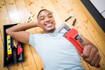 Man showing a wrench while working with a set of tools