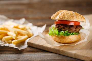 Homemade hamburgers and french fries on wooden table