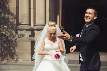 stylish gorgeous blonde bride and groom posing on the background