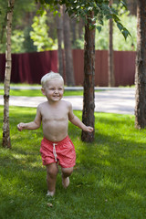 Portrait of blonde baby boy in red shorts