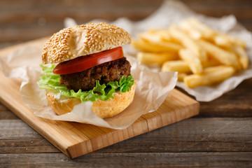 Homemade hamburgers and french fries on wooden table