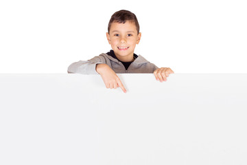 Advertising - Little kid standing behind a blank banner pointing to an advertisement isolated on white