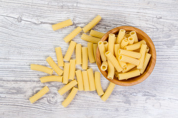 Various combinations of pasta on wooden background, burlap bags, bamboo bowls. diet and nutritional concept.