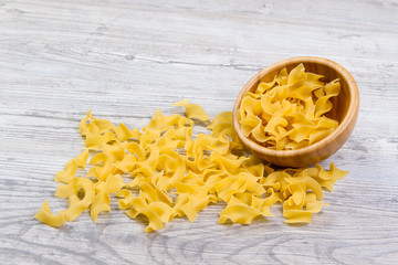 Various combinations of pasta on wooden background, burlap bags, bamboo bowls. diet and nutritional concept.