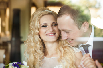 elegant stylish groom with his happy gorgeous blonde bride in th
