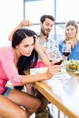 Friends looking drunk woman with wine glass