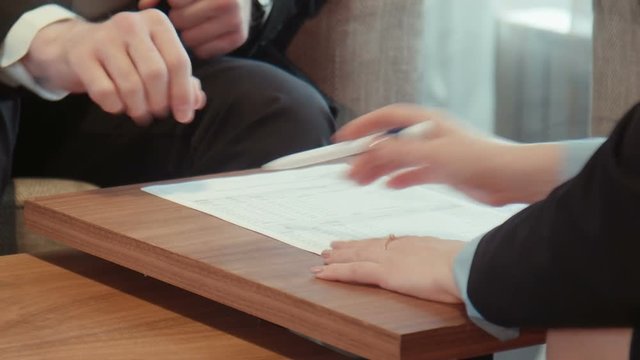 Business male and female in official suits sign paper