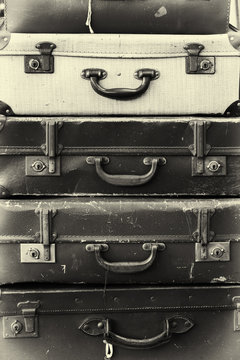 Stack of old battered suitcases with vintage style filter applied to image