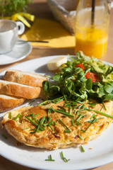 Herb omelette with chives and oregano sprinkled with chili flakes, garlic panini toasts
