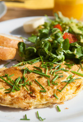 Herb omelette with chives and oregano sprinkled with chili flakes, garlic panini toasts