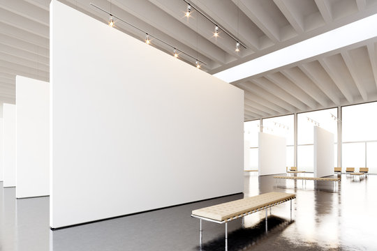 Image exposition modern gallery,open space.Blank white empty canvas hanging contemporary art museum.Interior loft style concrete floor,light spots,generic design furniture and building. 3d rendering