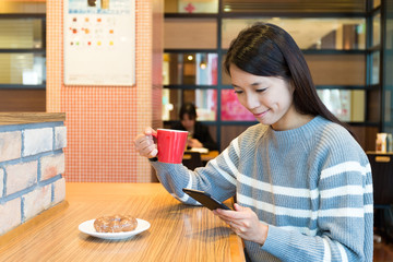 Woman enjoy her morning coffee with mobile phone