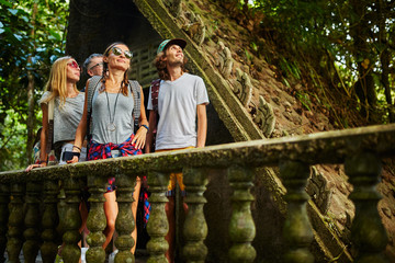 Naklejka na ściany i meble tourist exploring ancient jungle ruins in tropical rain forest on thailand adventure
