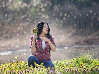 Girl sneezing on meadow