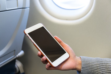 Woman use of cellphone inside air plane