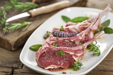 Rohes Lammfleisch mit Stiel mariniert auf weißem Teller
