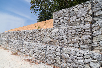 Slope retention management with rocks and wire mesh cage system