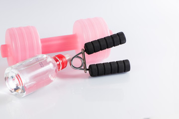 Fitness background with bottle of water, dumbbell and handgrip