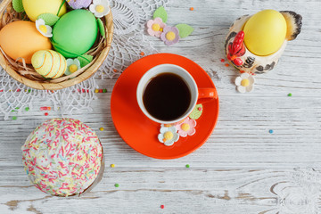 Obraz na płótnie Canvas Table setting for Easter - Easter cakes, coffee cup and colored