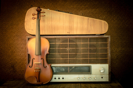 violin and old radio in vintage style on steel background