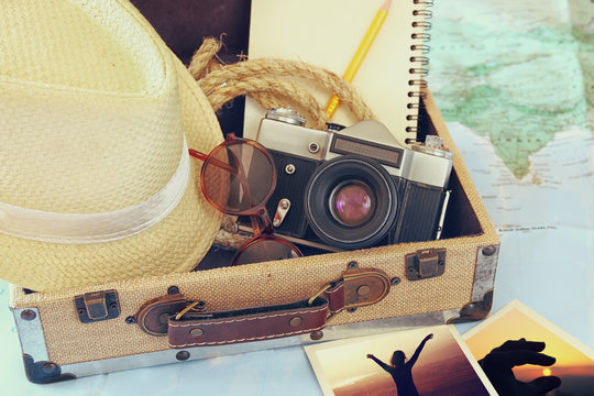 traveling concept. camera, cup of coffee, sunglasses, fedora hat and notebook. vintage style filtered. selective focus