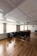 Fototapeta na wymiar Projector hang on ceiling of empty sunlit meeting room