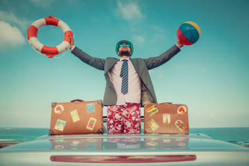 Businessman standing on a beach near car