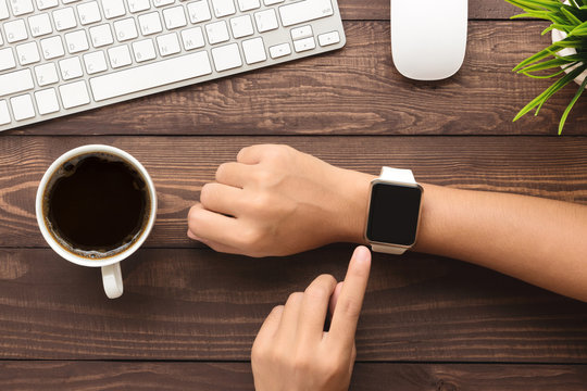 Hand Using Smartwatch On Desk Top View