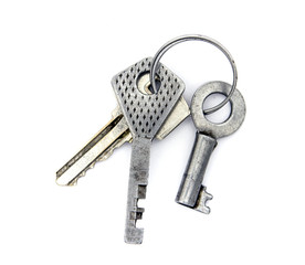 Keychain of three old steel keys of padlocks on ring on white ba