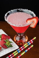 Strawberry margarita cocktail garnished with salt rim and slice of strawberry.