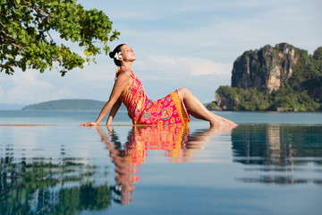 Woman in traditional thai summer dress enjoying travel and relax in Krabi, Thailand. Beautiful girl...