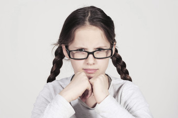 funny teenager girl looks angry behind her spectacles