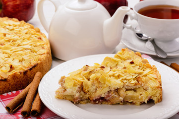 Apple pie with cream cheese and almond on white wooden background.