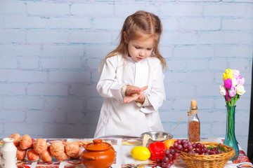 Little girl preparing dough for bread. Cute little girl in the kitchen preparing cookies. child chef