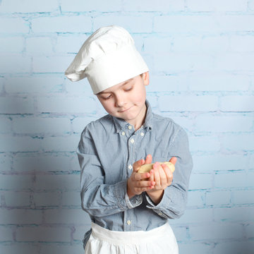 Little boy preparing dough for bread. Cute little boy in the kitchen preparing cookies. child chef