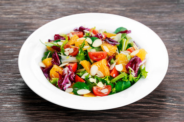 Fresh Orange, vegetables salad on wooden table.