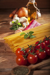 Pasta ingredients on wooden background