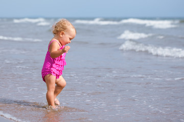 Little cute happy girl bathes in sea,  Italy, outdoor