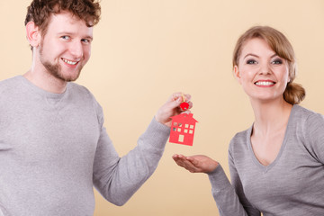 Couple holding key with house symbol