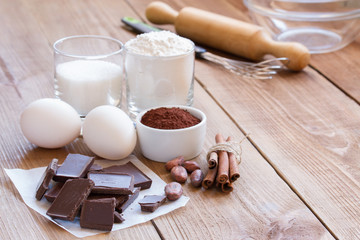 Ingredients for making chocolate chip cookies on a wooden background
